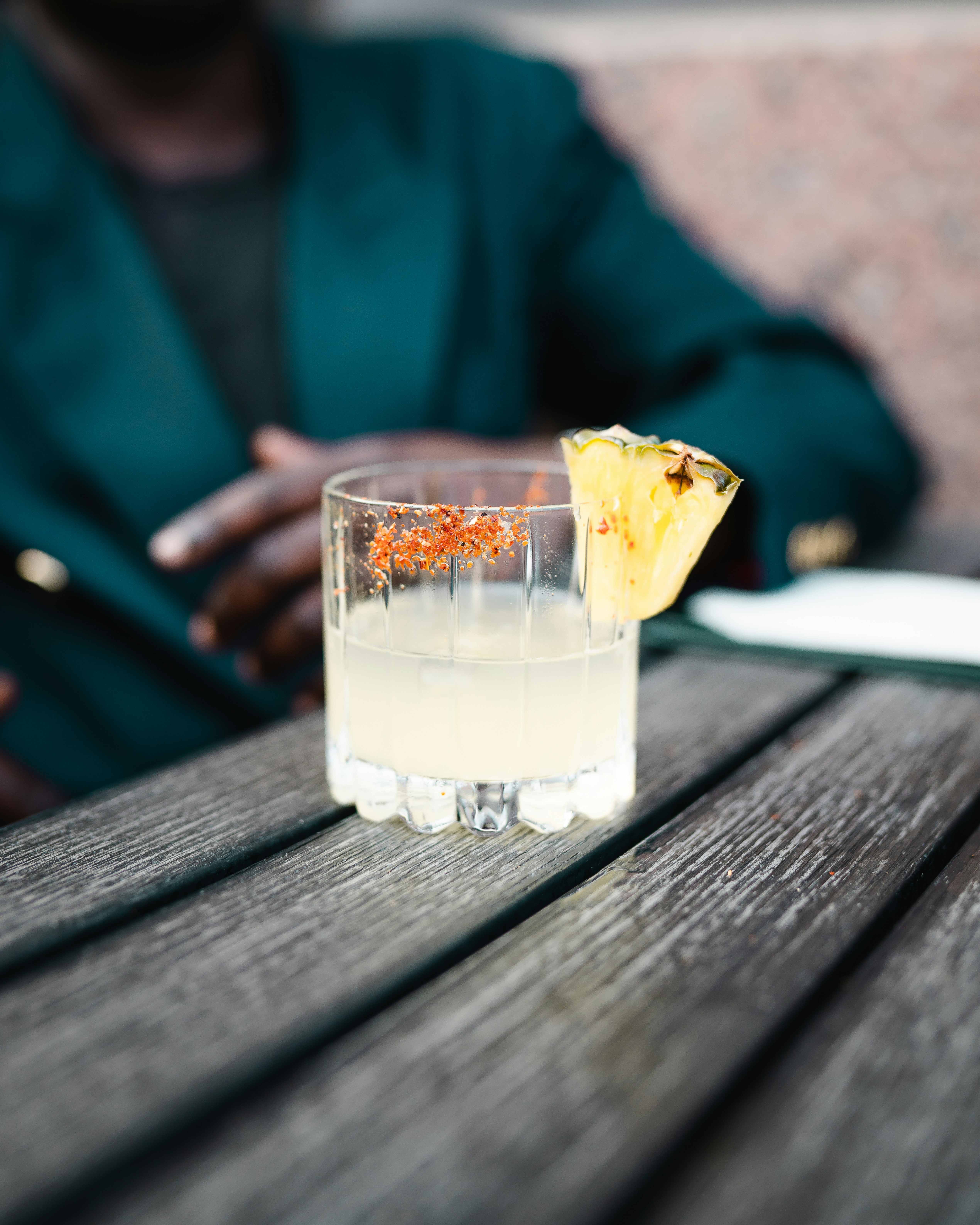 clear drinking glass with yellow liquid on brown wooden table